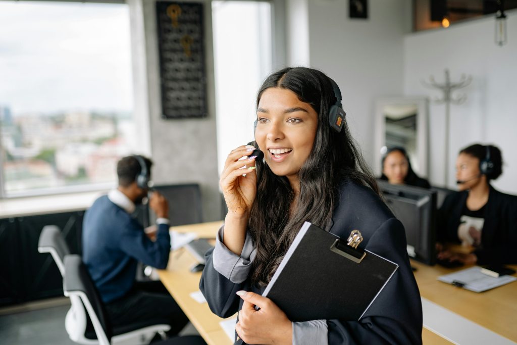 pexels photo 8867478 8867478 A smiling call center agent with headphones works in a modern office.